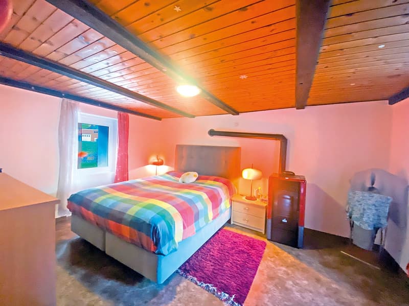 Bedroom with bed, nightstands, lamps, rug, wooden ceiling, pink walls, window with curtains