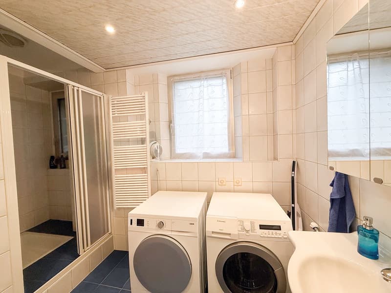 Bathroom with shower, toilet, washing machines and sink