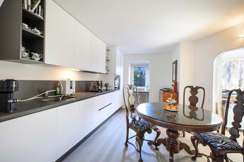 kitchen, table with chairs, large window, sink, appliances, wooden floors
