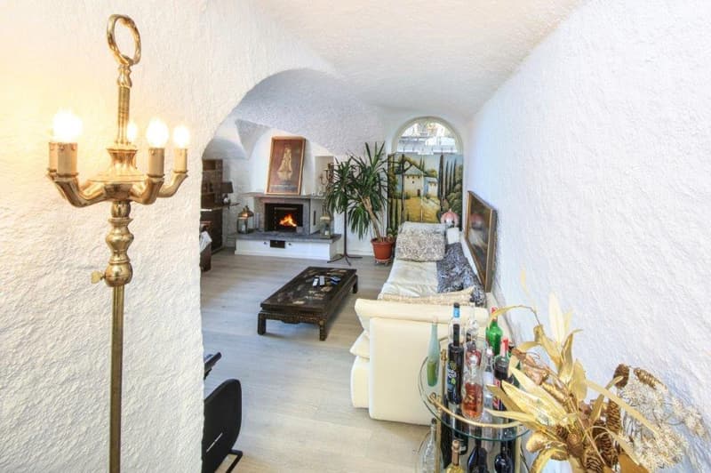The living room features a white couch, a coffee table, a fireplace, and a brass floor lamp.