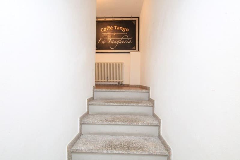 granite steps, radiator on the wall, signboard with text Cafe Tango