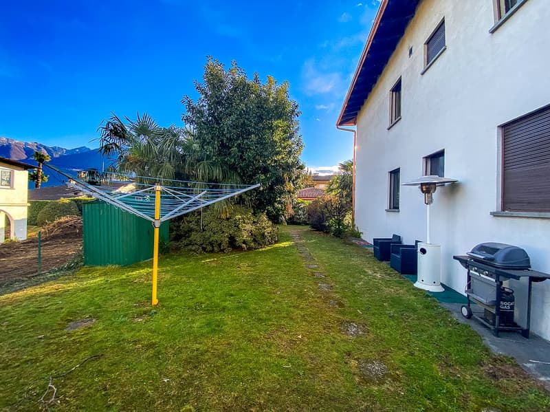 Lawn, green tree, garden tools, barbecue, chairs, lamp, paved path, view of the mountains