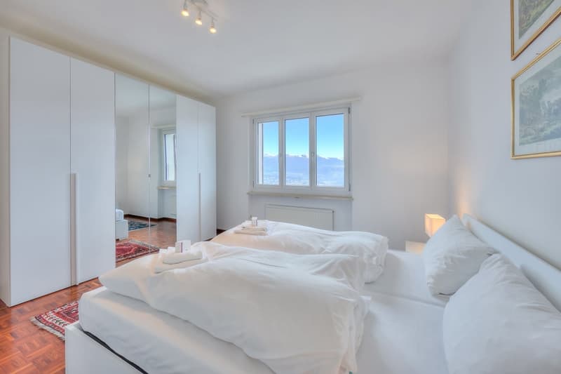 white theme, two beds, two bedside tables, two lamps, wardrobe, carpet, white towels, white curtains