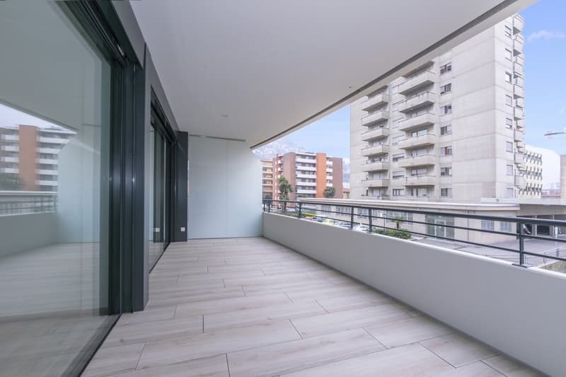 Balcony, wooden flooring, glass railings, large glass windows, high ceiling