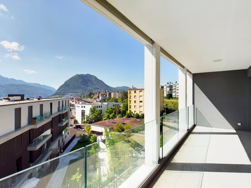 building terrace with glass railings, panoramic views of the surrounding mountains and buildings