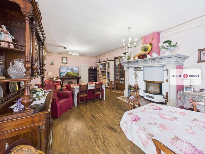 wooden flooring, pink wall, wooden furniture, table with chairs, TV, fireplace, shelves with decorations