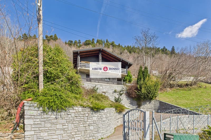 Detached house, wooden exterior, raised ground floor, located on a hillside
