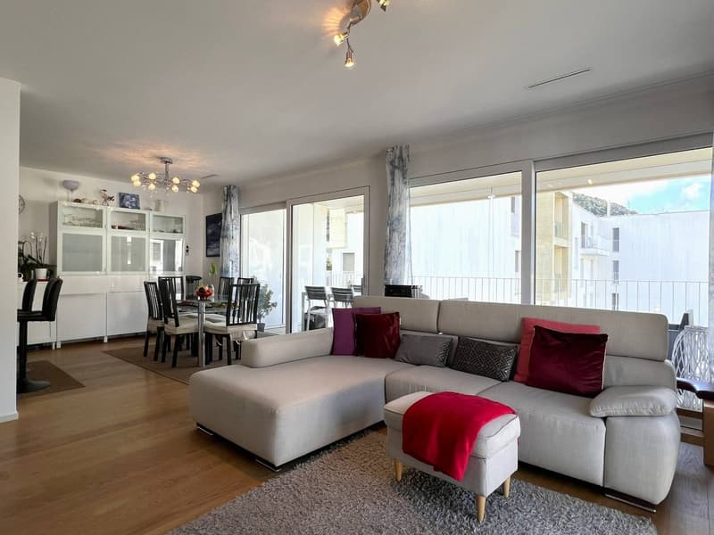 White sofa, coffee table, rug, large windows, balcony, dining table, chairs, floor lamps, chandelier, cabinets