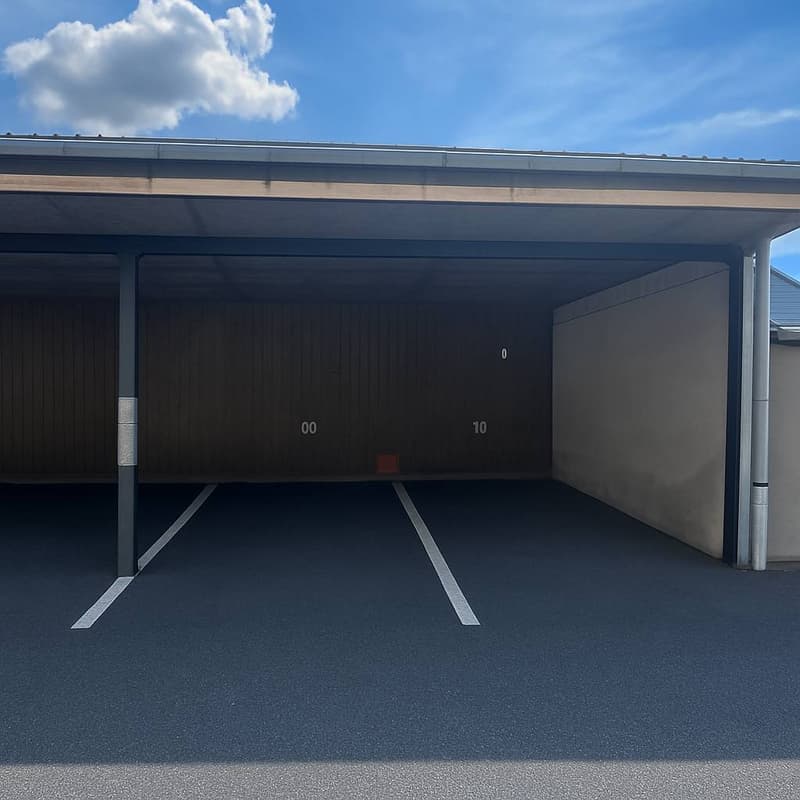 Covered parking area, asphalt ground, two parking slots, numbered posts