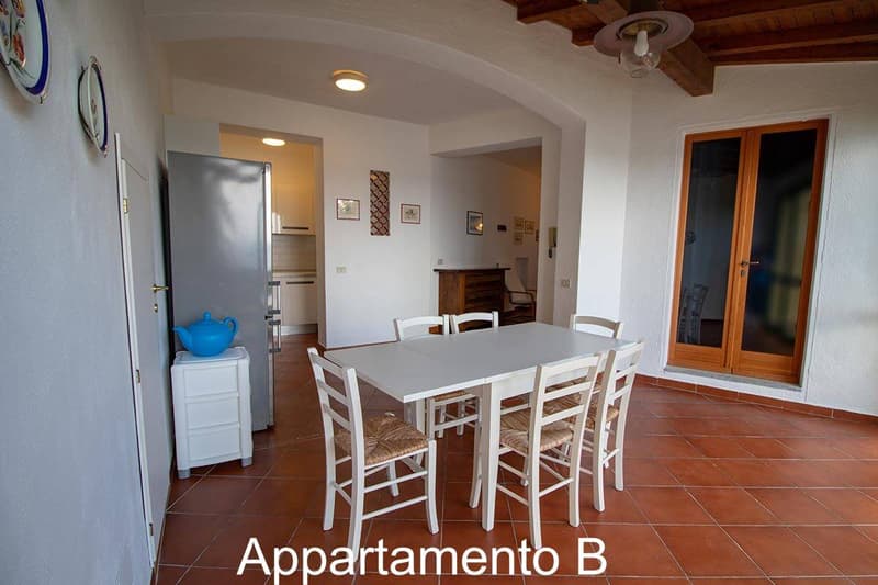 a dining table and chairs, white refrigerator, tile flooring, glass doors to outside, artwork on the wall