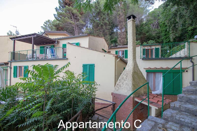 3 story house, beige walls, green shutters, balcony, stairs, chimney