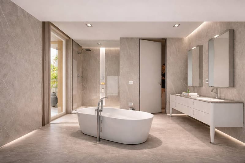 modern bathroom, large white bathtub, two sinks, two mirrors, marble walls, shower area