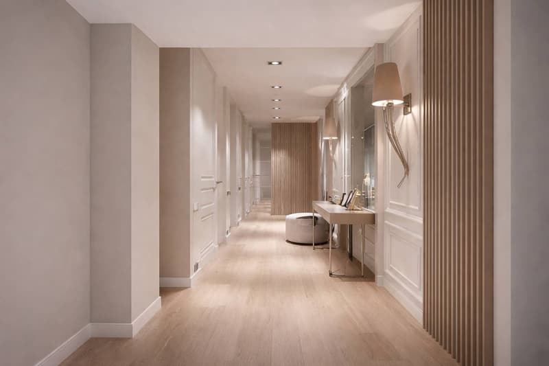 long hallway, wooden floor, white walls, white doors, wall lamps, small table, mirror