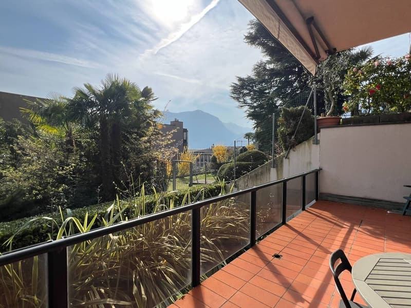 tiled floor, black railing, glass railing, table and chairs, plants, mountain view