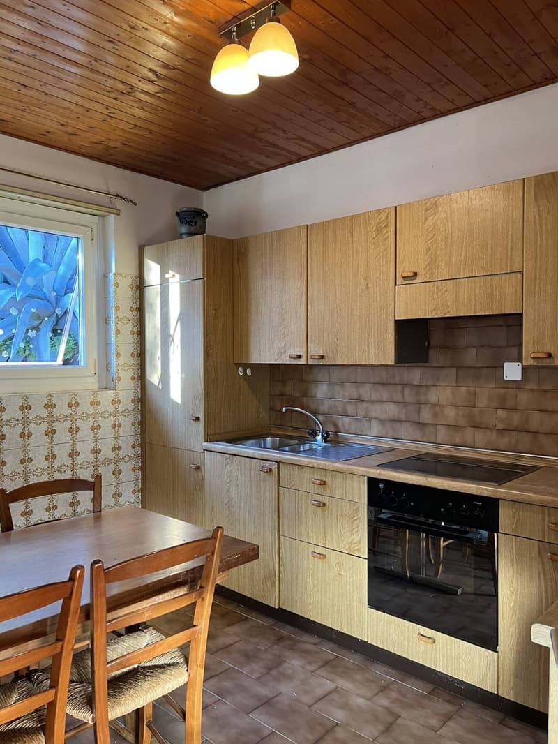 kitchen with wooden cabinets, tiled floor, sink, oven, dishwasher, dining table, chairs
