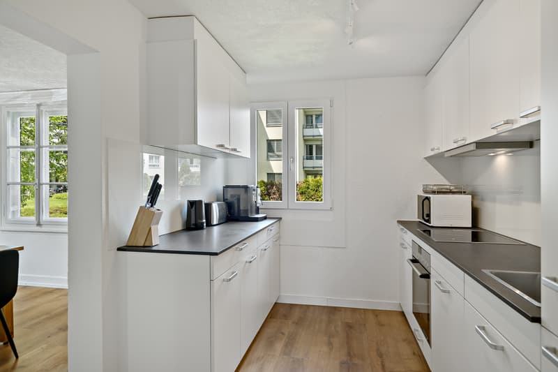 Küche mit Mikrowelle, Backofen, Kaffeemaschine, Kochfeld