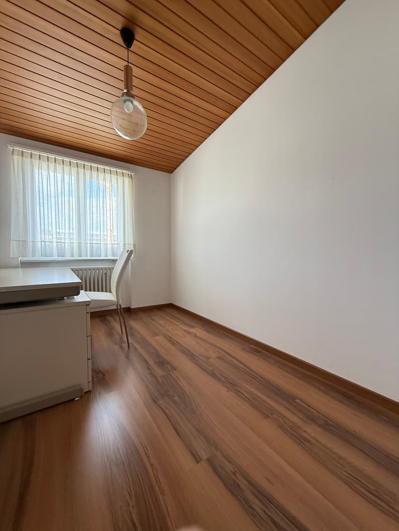 wooden floor, white wall, window with curtain, white desk, chair, lamp