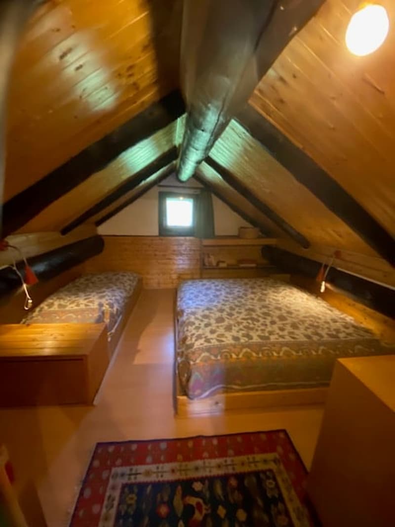 Two single beds, rug, wooden beams, small window