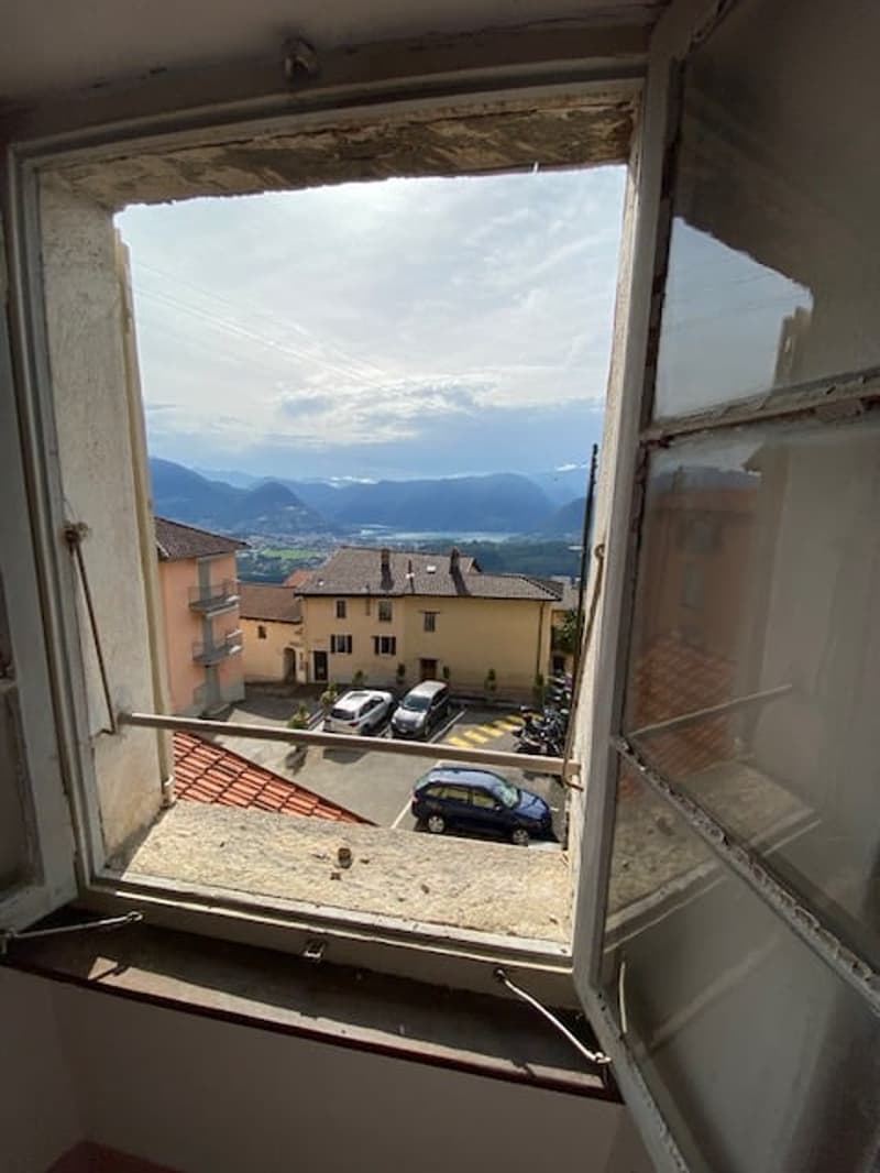 View of a building and cars parked in front, with mountains in the background