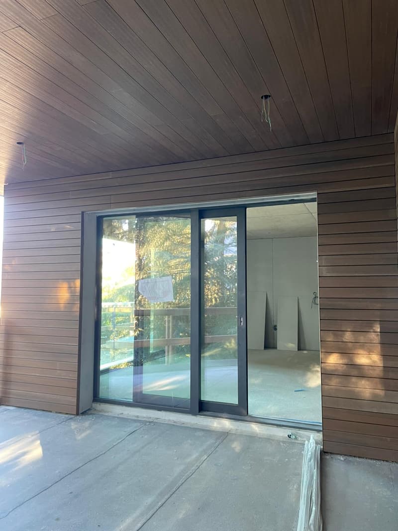 Sliding glass doors, brown wall, concrete floor, balcony