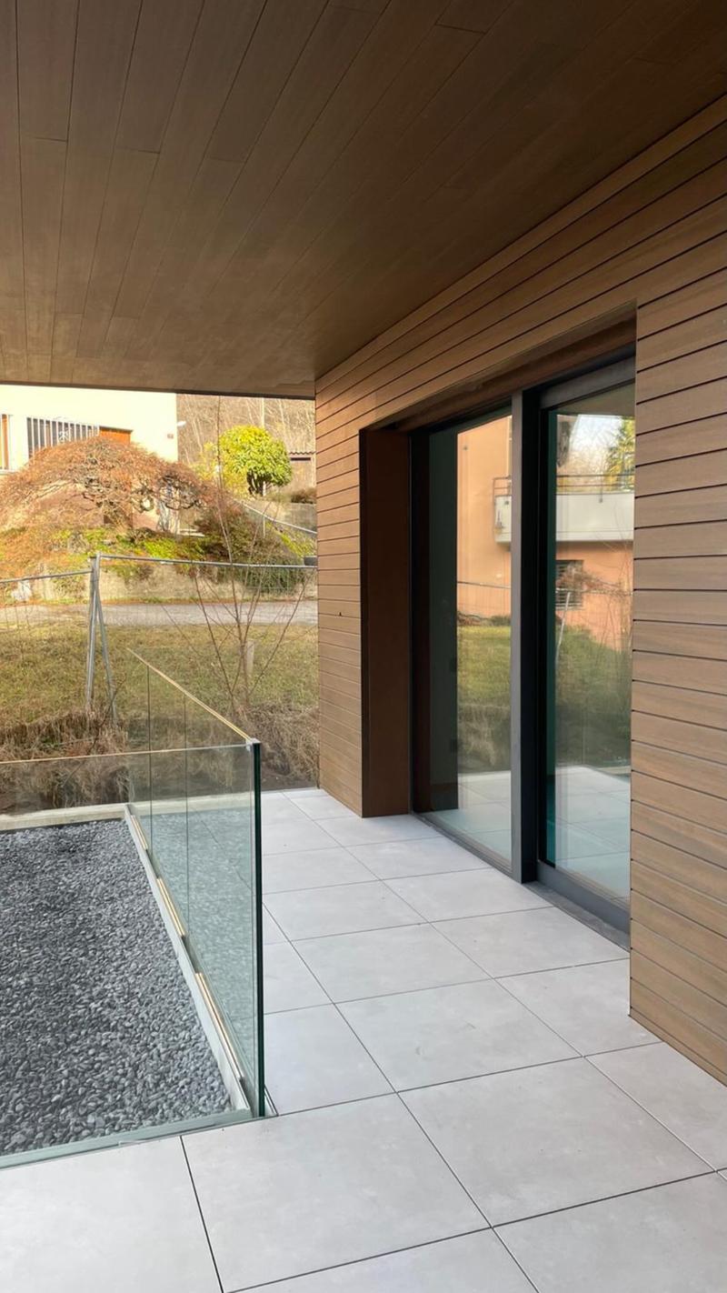 House exterior, terrace, glass balcony railing, white tiles, glass doors