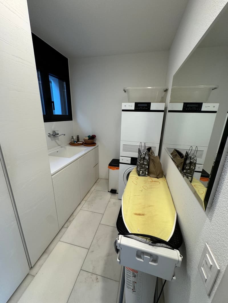 Laundry room with sink, washing machine, dryer, folding board, mirror