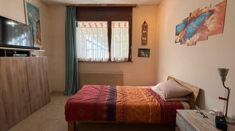 single bed, wooden nightstand, TV, heater, bedheadboard with decorations