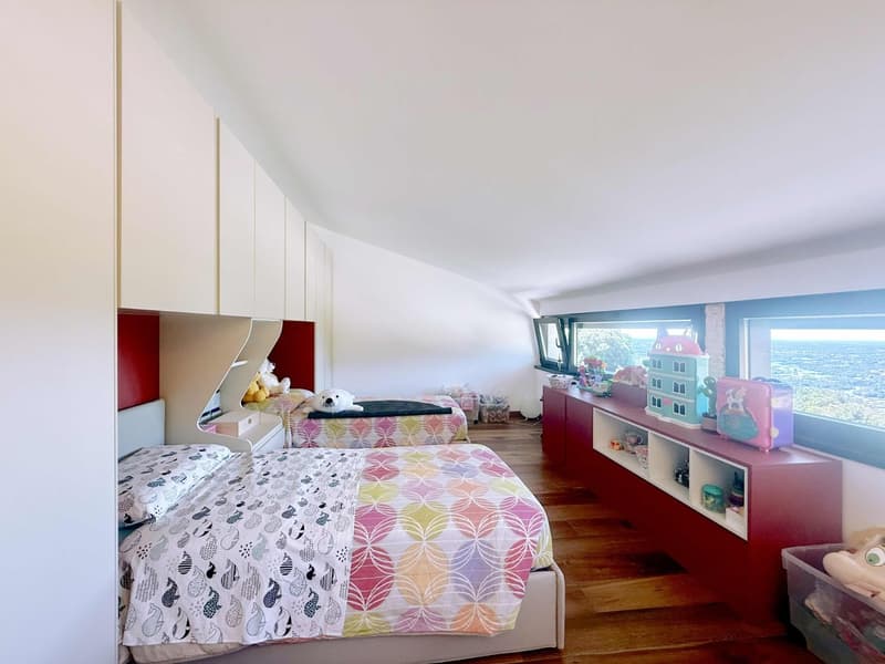Two beds, wooden floor, white walls, red cabinets, large windows, view of the sea
