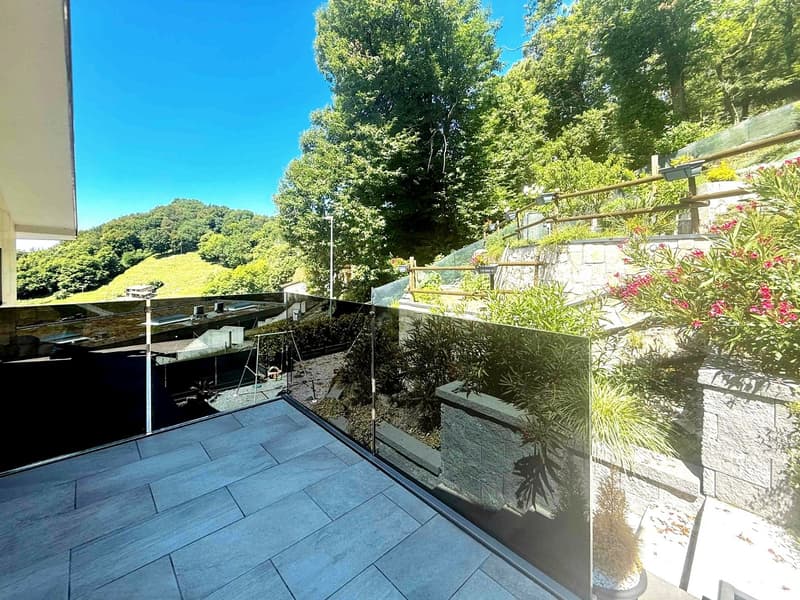 glass railing, tiled floor, plants, greenery, distant mountain view