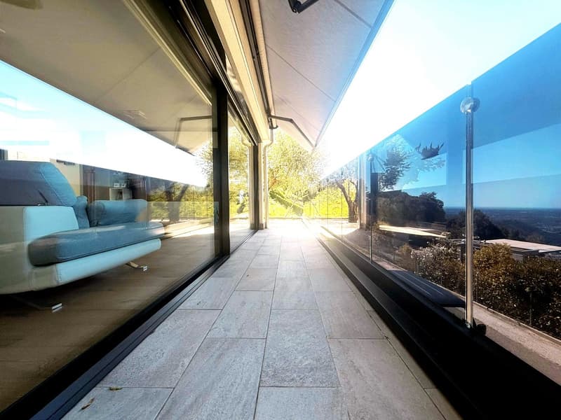 large glass walls, balcony, modern furniture, tiled floor, scenic view