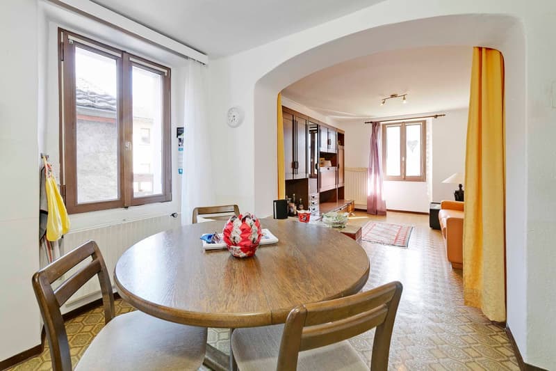 wooden table, chairs, living room, shelves, couch, lamp, window, clock, radiator