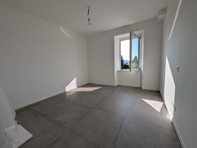 empty room, white walls, gray tile floor, window, power outlets