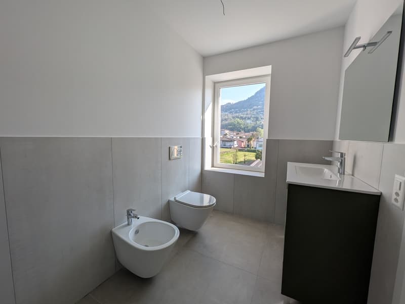 modern bathroom with white walls, white toilet, white bidet, white sink, mirror, window with view