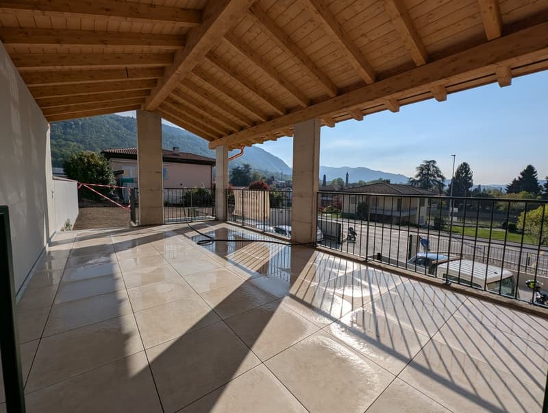 covered terrace with wooden ceiling, tiled floor, black railings, view of mountains and road