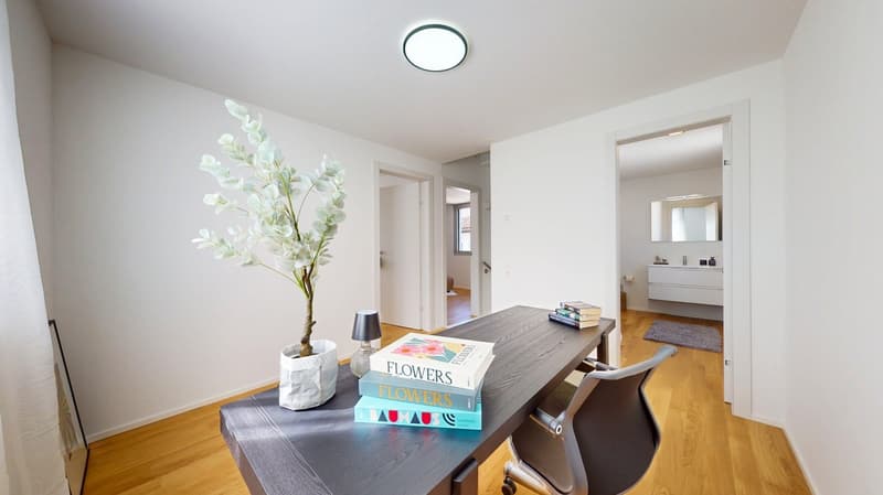 desk with books, plant, lamp, chair, white walls, wooden floor