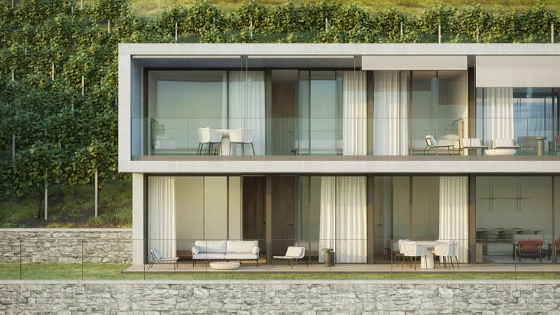 two-story building, glass walls, balconies, outdoor seating, stone walls, green vegetation in background