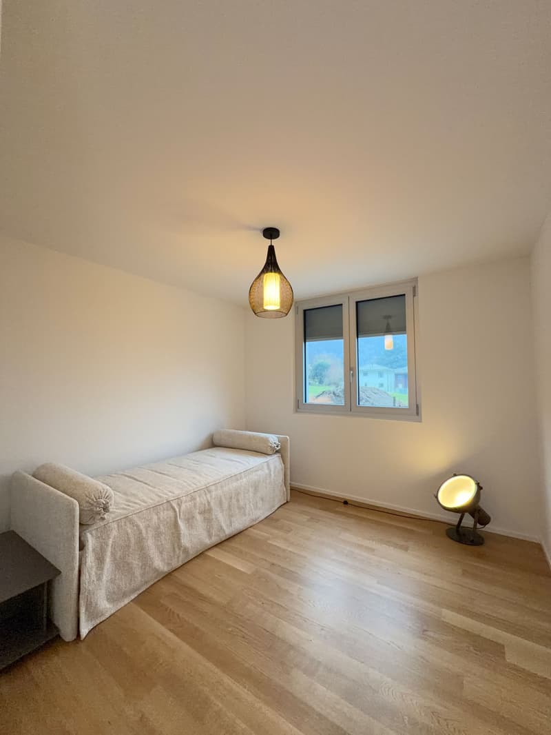 Bedroom: bed, wooden floor, large window, pendant light, small lamp