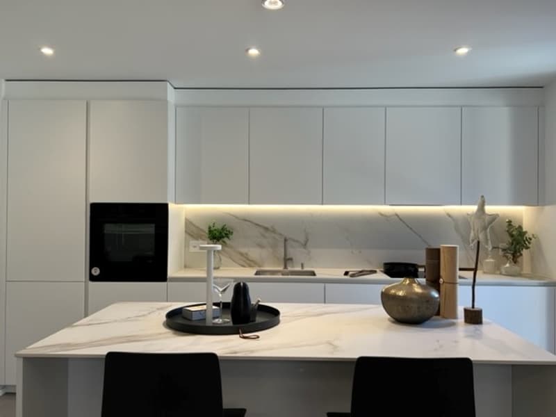 Modern kitchen with marble countertop, white cabinets, integrated oven, faucet, and sink.