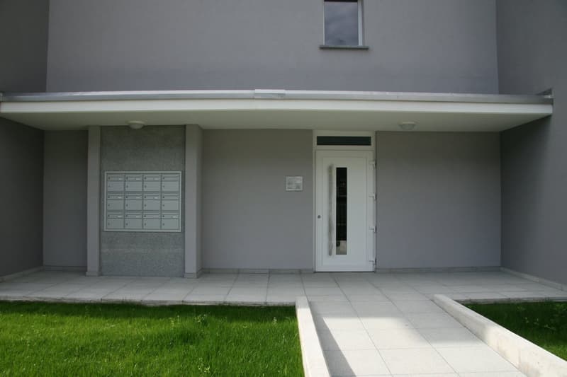 modern house, gray exterior, white door, mailbox, tiled floor, small garden