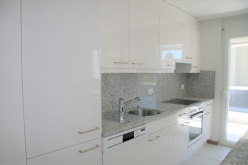modern kitchen with white cabinets, granite countertops, stainless steel sink, dishwasher, gas stove, oven, and a window