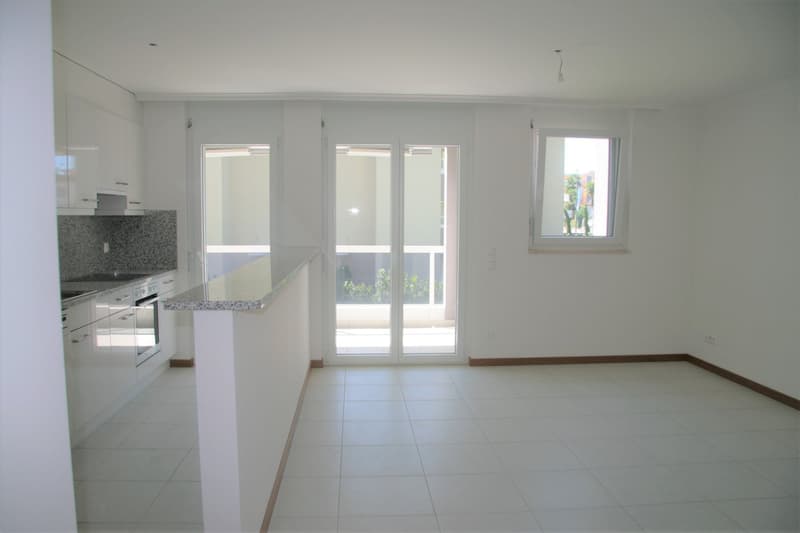 modern kitchen with white cabinets, granite countertops, large windows, balcony