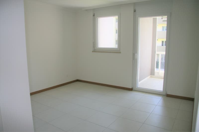 empty room, white walls, white tiles, window, sliding door to balcony