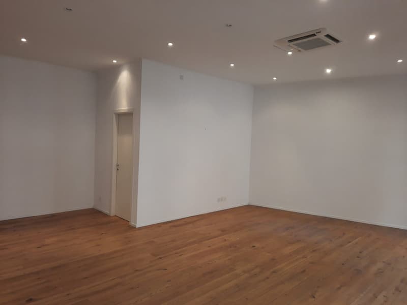 empty room, wooden floor, white walls, ceiling light, white door, white air conditioner
