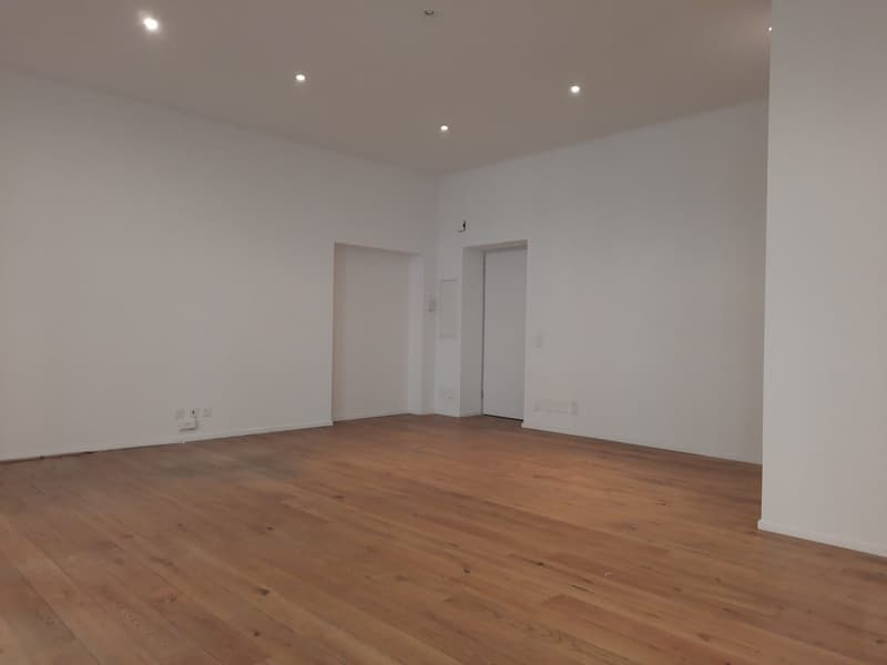 empty room, hardwood floors, white walls, power outlets, and two doors