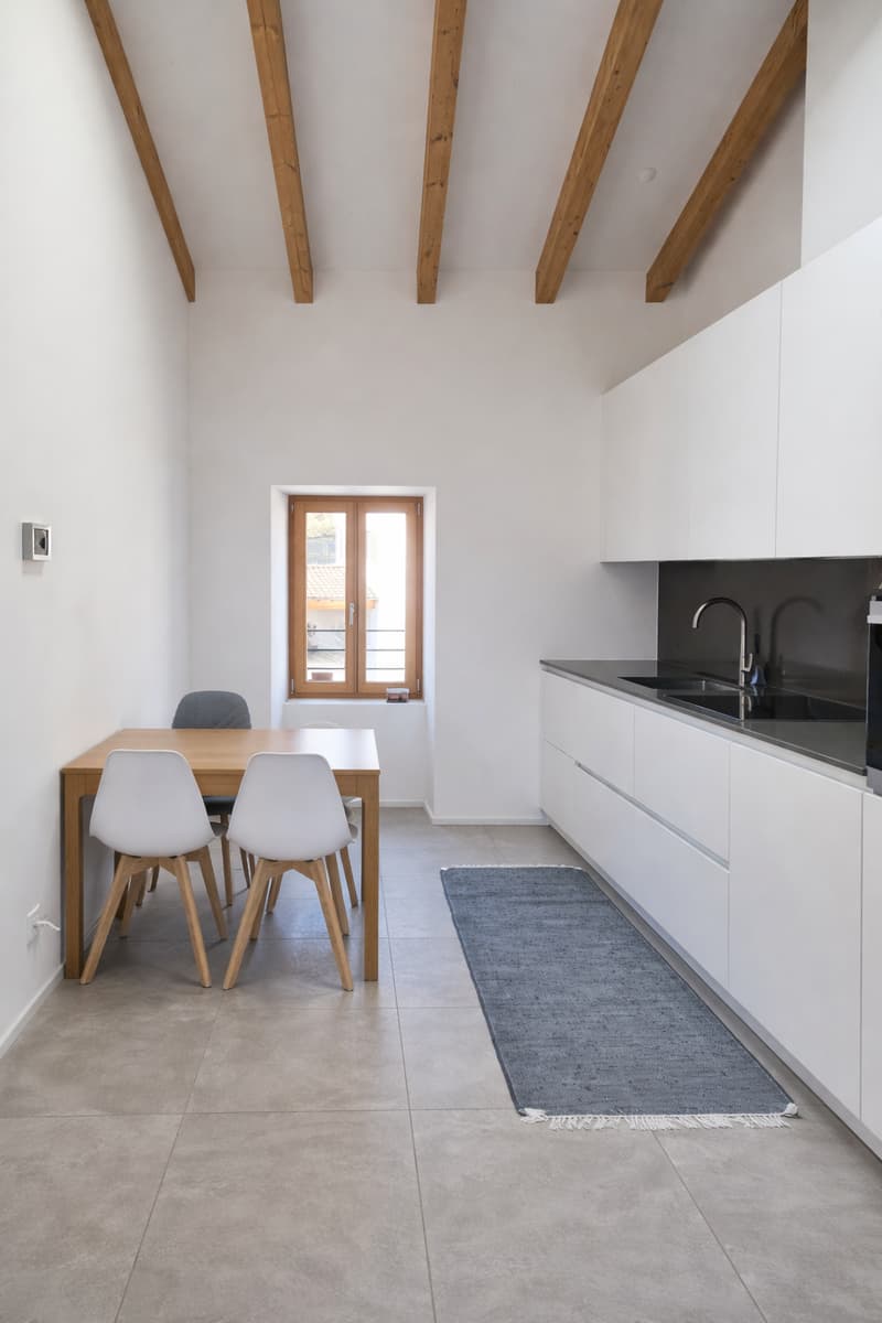 Contemporary kitchen with dining area, wooden ceiling beams, modern furniture, minimalist design
