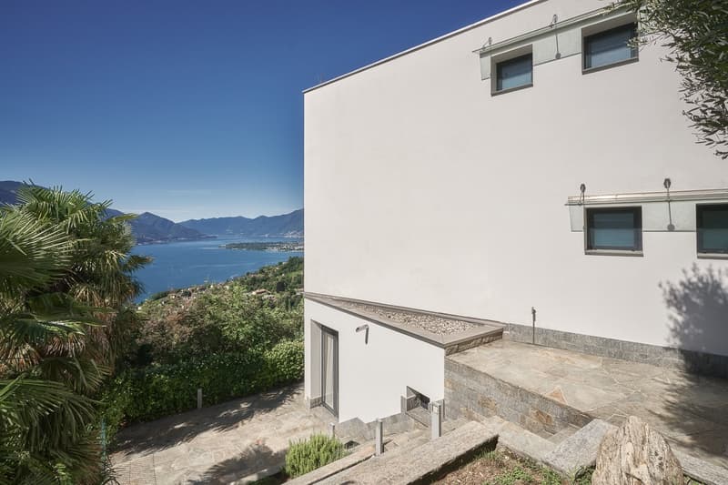 Modern white exterior, concrete steps leading to entrance, view of mountains and water