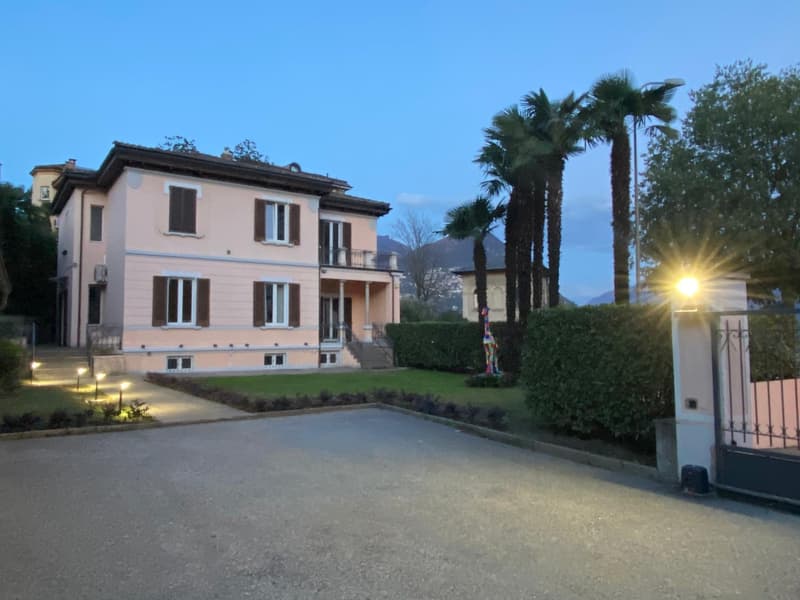 Villa, large pink exterior, balcony, palm trees, driveway