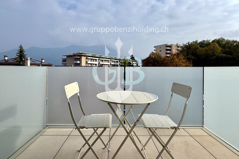 Table and chairs on a balcony with a view of the city and mountains