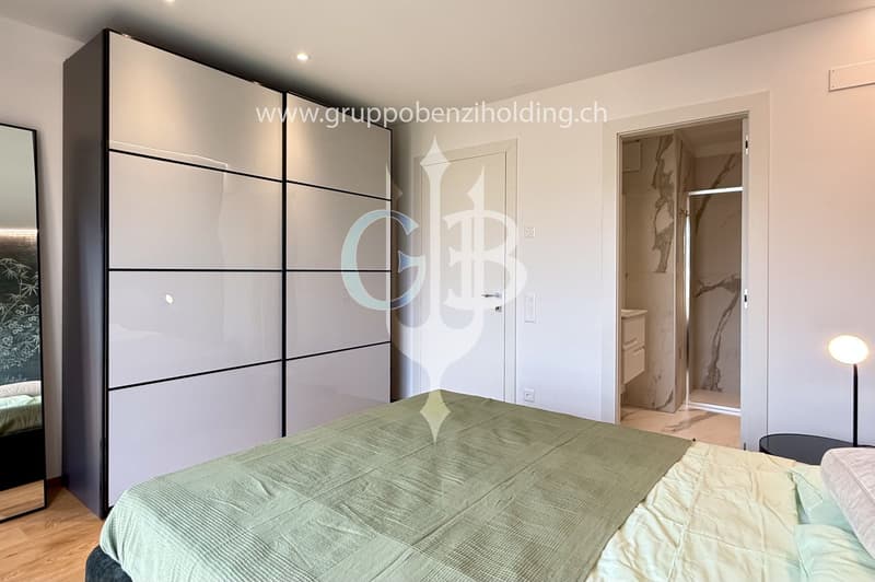 large wardrobe, bed, wooden floor, nightstand, lamp, bathroom in the hallway
