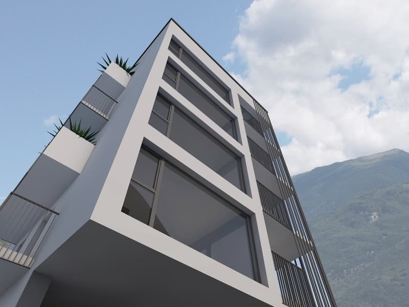 Modern multi-story building with a geometric facade, large windows, and balconies. The building has a sleek, contemporary design with a mix of gray and white colors. There are plants visible on some of the balconies.
